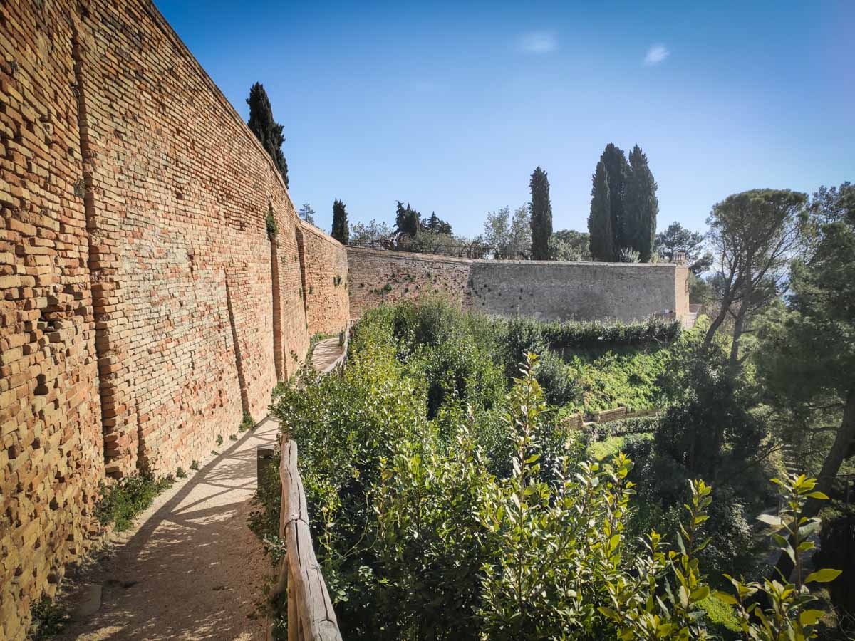 ingresso del parco del Colle dell'Infinito a Recanati, arco in mattoni e viale alberato con vista sulle colline