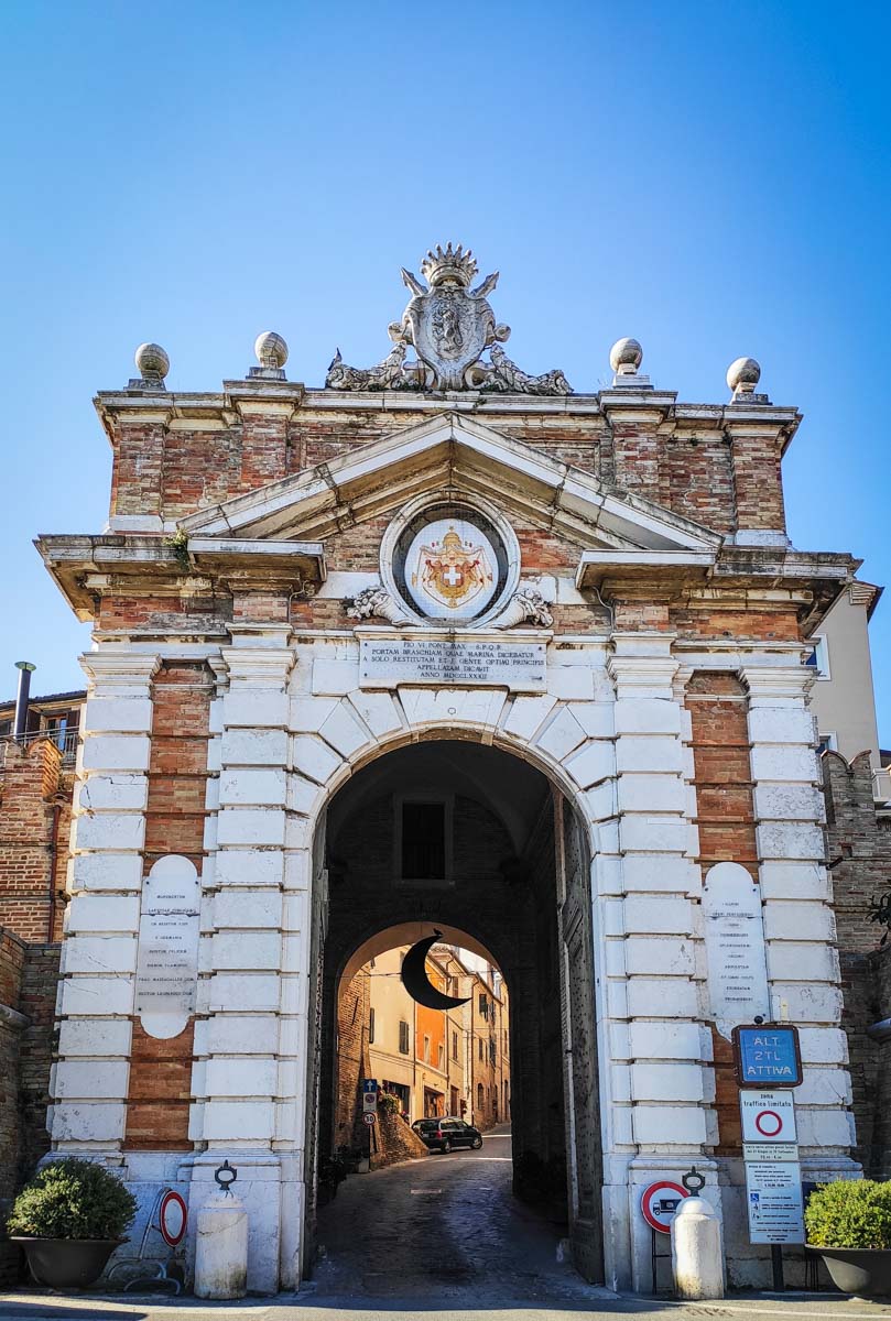 Porta Marina di Recanati, arco monumentale in travertino chiaro con stemma e passaggio carrabile