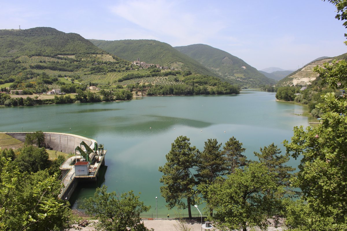 il Lago di Caccamo visto dall'alto con la diga sulla sinistra, l'acqua verde e le colline coltivate intorno